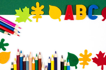 long school banner with school supplies crayons and decorative autumn leaves. Back to school concept. Colored pencils isolated on white background. Copy space
