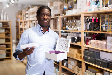 Fototapeta premium Male shopper chooses wooden box in furniture shop