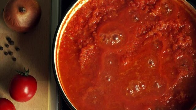 Close up of top view of boiling tomato Italian sauce for pasta or pizza cook on stove in saucepan. Cooking food