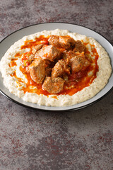 Hunkar Begendi Meat Stew over Eggplant Sauce closeup in the plate on the table. Vertical
