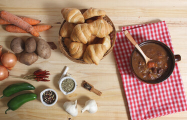 Beef Stew and Fresh Bread in Rustic Kitchen With Red and White Checkered Cloth