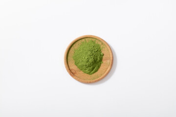 Green matcha powder on white background. Matcha made from finely ground green tea powder. Eat healthy because of high antioxidants.