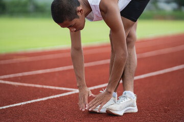 Athletes sport man runner wearing white sportswear to stretching and warm up before practicing on a...