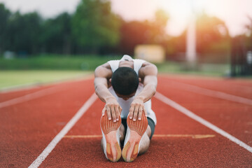 Athletes sport man runner wearing white sportswear to stretching and warm up before practicing on a...