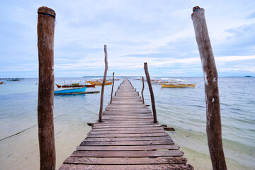 Fototapeta premium Beautiful landscape with fishing boats and wooden pier on seashore.