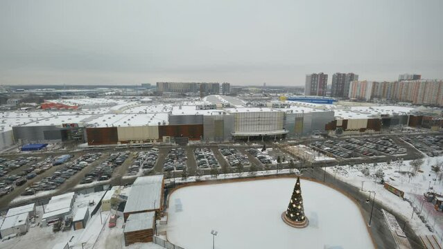 Timelapse of heavy snowfall in contemporary city upper view. Christmas skating rink and large parking site by shopping center in winter. Urban scene