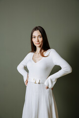 a girl in a white dress with high boots on a green background