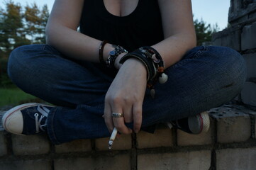 person with a cigarette sitting on crossed legs