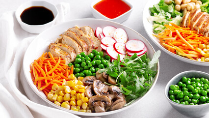 Chicken buddha bowl with meat, colorful vegetables on base of brown rice.