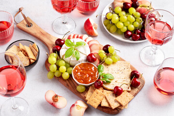 Healthy mediterranean cheese and fruits board with rose wine on light background