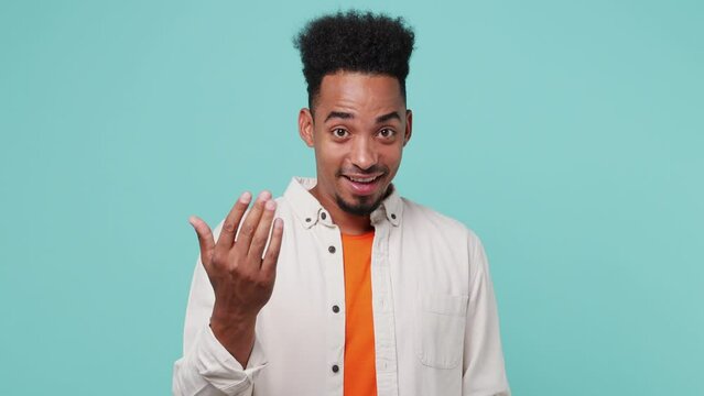 Young fun man of African American ethnicity 20s he wear shirt t-shirt looking camera rubbing fingers showing cash gesture ask for give me money beg isolated on plain pastel light blue cyan background