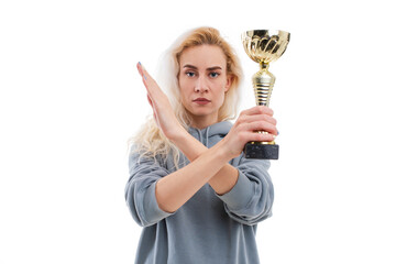 The young woman crossed her hands. In the hands of the model is a gold cup. The concept of stopping the competition due to a pandemic