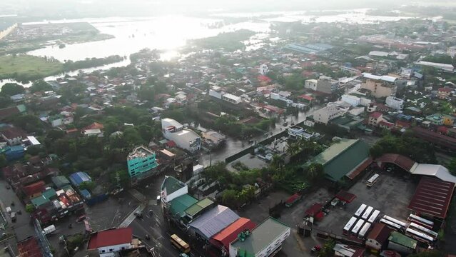 Drone aerial rotating view showing the cityscape and some submerged places and highways cause of tropical storm from Dagupan City, Philippines