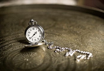 Vintage pocket watch on Arabic Brass table