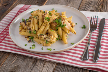 Penne with scrambled eggs, red onions and chicken ham on a plate