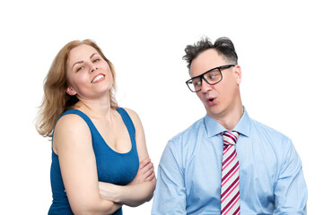 Funny man in glasses and a tie looks askance at the bust of a happy woman in a tight dress, who is...