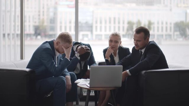 Sad multiethnic partners disappointed in corporate failure. Realtime