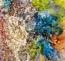 Golden dust and drops of various size on Alcohol ink fluid abstract texture fluid art with gold glitter.