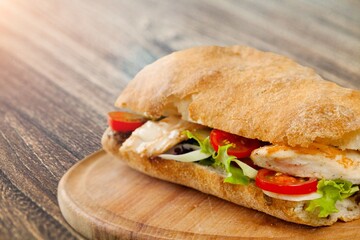 Baguette tasty fresh sandwich with fresh vegetables on desk