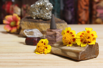 Obraz na płótnie Canvas Yellow Flowers on Petrified Wood With Rock Crystals and Incense Cone