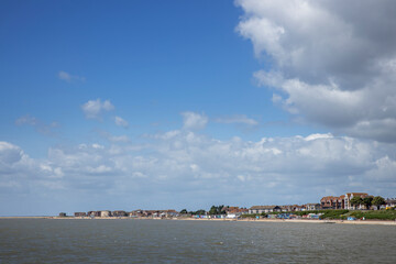 Fototapeta na wymiar Clacton on sea. Essex. England. UK, Great Brittain. Seaside resort. Clouds and shoreline. Beach and sea. 