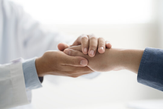Doctor or psychiatrist shakes hands encouragement the patient and care having a consultation on diagnostic examination on male disease or mental illness in a clinic or hospital mental health service
