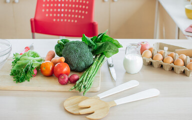 Background with nobody of fruits, pineapple, banana, pomegranate, red and green apples for good health decorated on wooden table in cozy white clean kitchen . Healthy food, interior Concept.