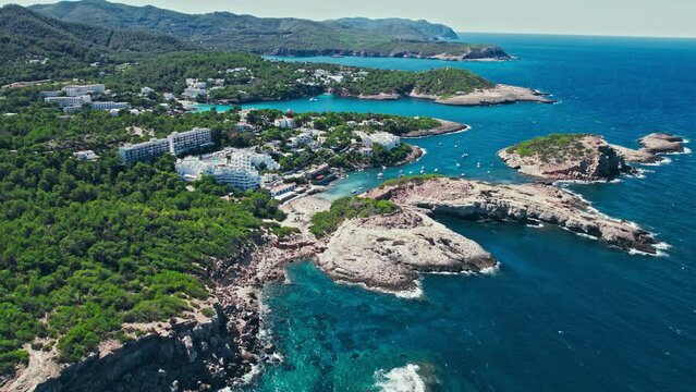 Luxury villas, mansions, apartments and hotels in Portinatx, Ibiza, Spain. Scenic view of modern buildings and resorts in the middle of the nature of the Balearic Islands on a summer day.