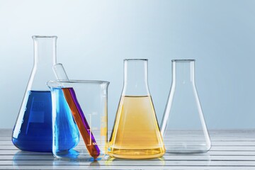 Unrefined sunflower oil in chemical flask on desk background.
