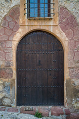 old wooden entrance door in a stone wall in a medieval village