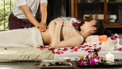Asian woman enjoying a salt scrub massage at spa. Healthcare spa and massage thai concept  Girl...