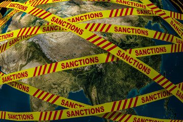 Close-up. The planet Earth is surrounded by a yellow ribbon with the inscription "sanctions". A symbol of the suffering of the whole world from sanctions due to the war in Ukraine. 3d rendering.