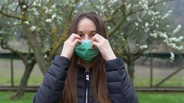 Woman in despair removing medical mask looking on camera and smiling, person being tired of global deterioration of the situation due to dangerous virus spreading all over the world. Light smile on