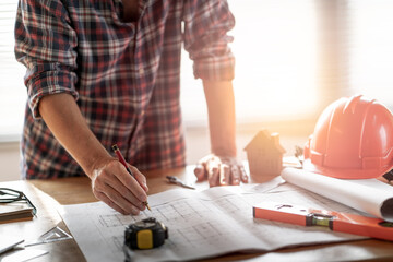 Architect & Engineer working drawing document about project planning and progress of work schedule on the home building construction site