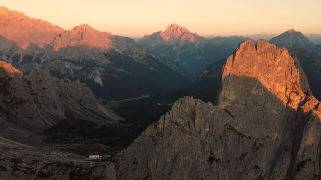Amazing sunrise view of Rifugio Fratelli Fonda Savio and the stunning rock formations and mountains surrounding the guest house with beautiful colors of the sun - The Dolomites - South Tyrol - Italy
