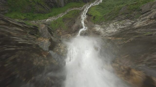 Dynamic descending flight over splashing waterfall in Norway named Skytjefossen in Norway