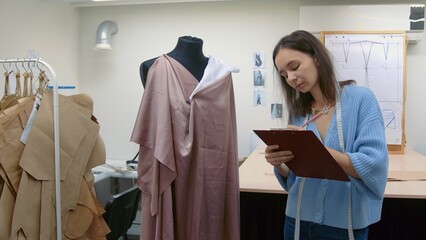 4K. Seamstress creates an individual dress in the workshop
