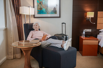 Gray-haired woman holding a tablet and looking thoughtful