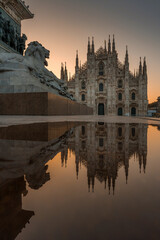 Sunset Scene of The ornate gothic facade, soaring spires and magnificent marble towers of the Duomo, Milan's monumental cathedral under big blue Lombardy skies - 522236565
