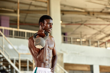 Attractive african american man smiling and doing exercise with dumbbells.