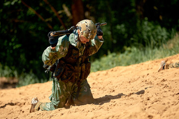 Naklejka premium Special forces soldier with weapon take part in military maneuver. War, army, technology and people concept