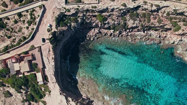 A beautiful cave beach on Formentera Island by Ibiza, Balearic Islands, Spain. Cala en Baster - relaxing beach with blue and turquoise mediterranean sea water.