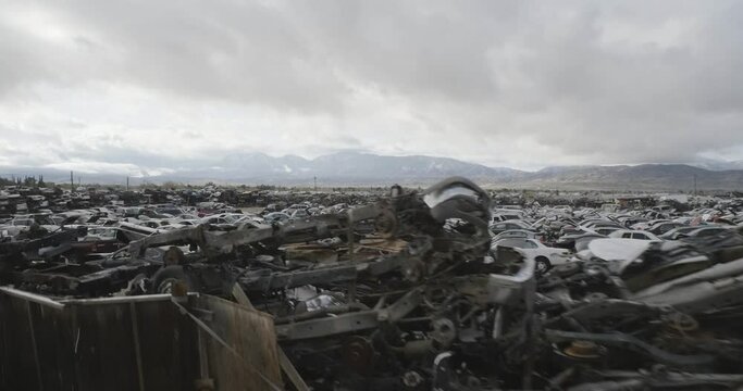Aerial of vast california desert junkyard with millions of cars in piles and rows