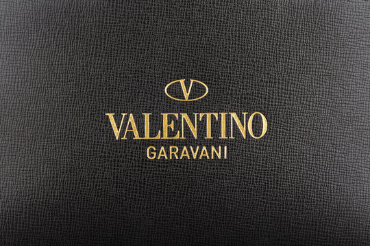 VALENTINO Garavani logo, embossed on black textured leather in golden color. Advertising shooting, Belarus, Minsk, 16.11.2021. Top fashion brands.