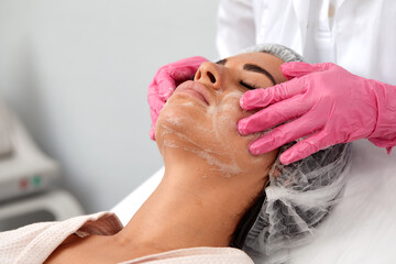 Woman having cleaning facial treatment in spa