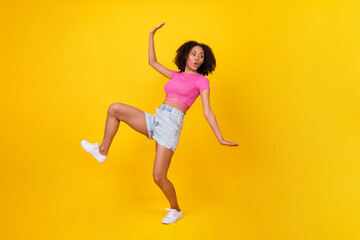 Fototapeta na wymiar Full body portrait of impressed pretty girl sneaky walking pouted lips look empty space isolated on yellow color background