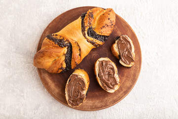 Homemade sweet bun with chocolate cream on a gray. top view.