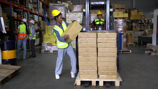 Worker in the warehouse factory carry stack box on the folklift truck not safety an accident happen box fall down hit her leg and fall down to floor
