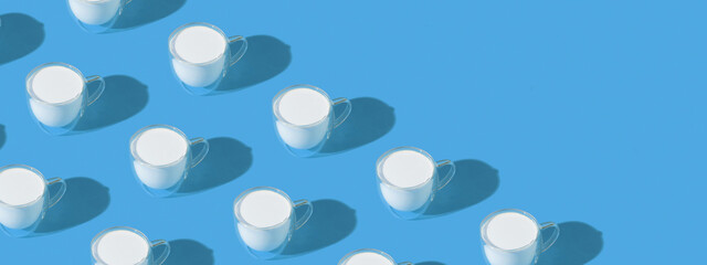 Fototapeta na wymiar Banner with milk in a glass pattern on blue colored background, dairy diet concept with copy space