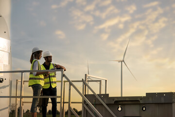 Fototapeta premium workers on the site. two engineers discussing against turbines on wind turbine farm.